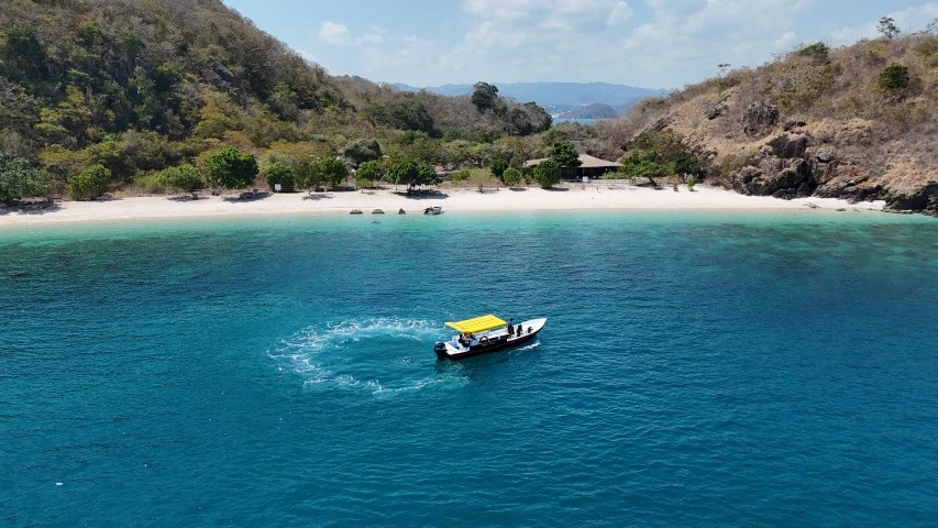 Lancha rápida de buceo Spyro frente a una playa de Komodo – vista aérea